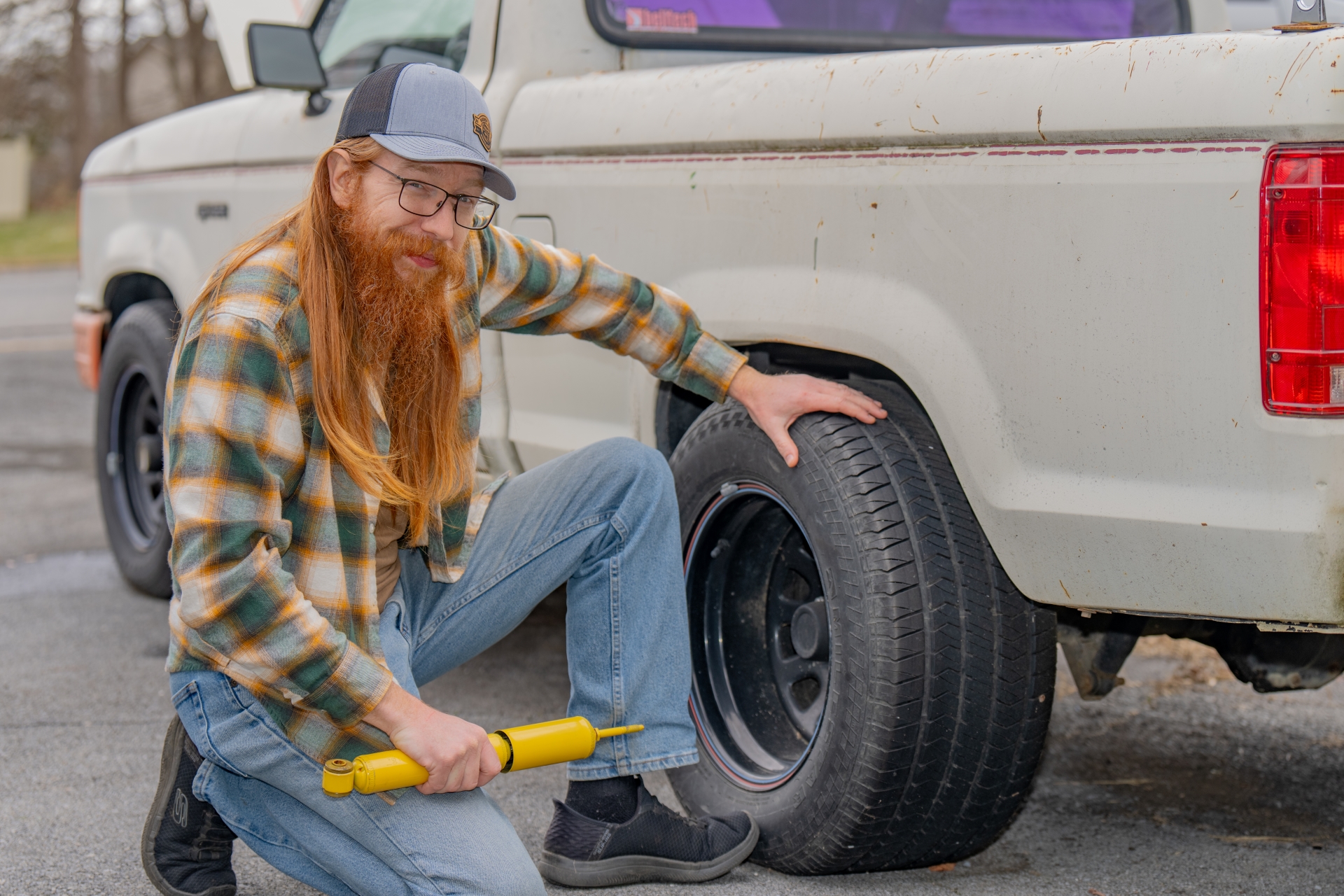 Image of Handy Red kneeling next to a truck.